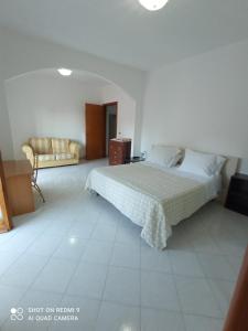 um quarto com uma cama e um sofá em Casa vacanza Ospedaletto d'Alpinolo em Ospedaletto dʼAlpinolo