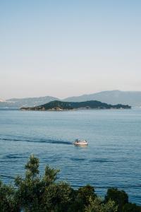 una barca in mezzo a un grande bacino d'acqua di Cape Blue Suites ad Achladies