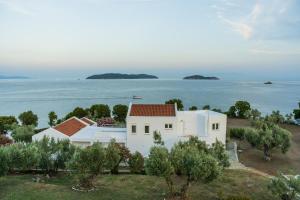 ein weißes Haus mit Meerblick in der Unterkunft Cape Blue Suites in Achladies