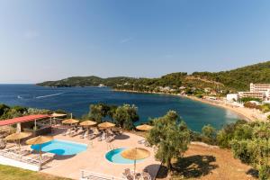 Blick auf einen Strand mit Sonnenschirmen und ein Resort in der Unterkunft Cape Blue Suites in Achladies