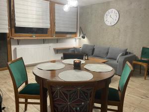 ein Wohnzimmer mit einem Tisch und einem Sofa in der Unterkunft Apartamenty Stronie Śląskie in Stronie Śląskie