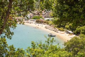 a beach with chairs and a boat in the water at Cape Blue Suites in Achladies