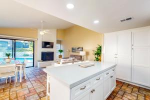 uma cozinha com armários brancos e uma sala de estar em Coastal Family Fun in the San Diego Sun em Oceanside
