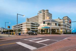 a building with a truck parked in front of a street at Beach Quarters Resort in Virginia Beach