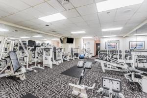 una sala de fitness con cintas de correr y máquinas en Beach Quarters Resort, en Virginia Beach