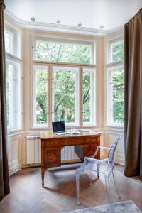 a desk with a laptop on it in a room with windows at Elegant Paris Ave apartment with a Terrace in Prague