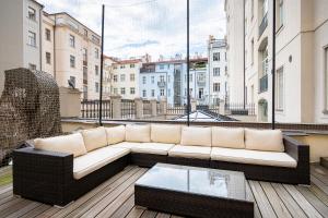 a white couch sitting on top of a balcony at Elegant Paris Ave apartment with a Terrace in Prague