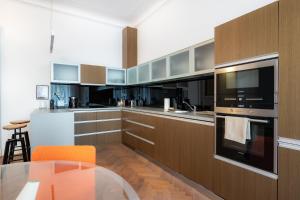a kitchen with wooden cabinets and a glass table at Elegant Paris Ave apartment with a Terrace in Prague