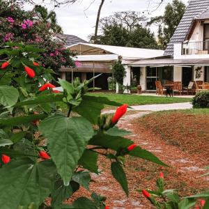 uma casa com flores vermelhas no quintal em Ars Amici Hotel em Punta del Este