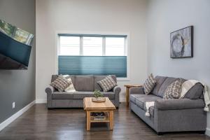 a living room with two couches and a table at Mountain Dreams - Revelstoke Home Near RMR in Revelstoke