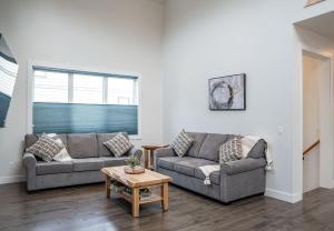 ein Wohnzimmer mit zwei Sofas und einem Tisch in der Unterkunft Mountain Dreams - Revelstoke Home Near RMR in Revelstoke