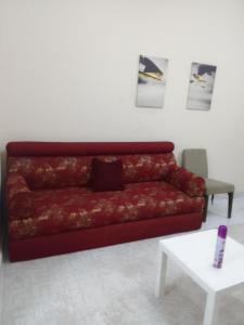 a red couch in a living room with a table at استوديو مفروش in Sharjah