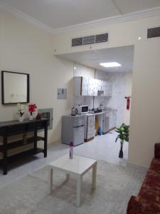 a living room with a table and a kitchen at استوديو مفروش in Sharjah