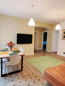 a living room with a table and a flat screen tv at Art flat in center near to sea in Blanes