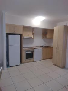 a kitchen with wooden cabinets and a white refrigerator at Ocean Breeze Apartments in Hervey Bay
