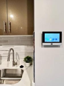 uma cozinha com um lavatório e uma televisão na parede em 303 Cozy and modern 1BR apartment in center City em Filadélfia