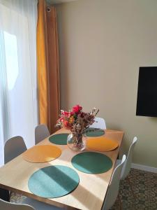 a wooden table with a vase of flowers on it at Art flat in center near to sea in Blanes