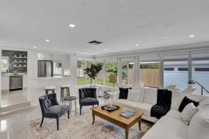 a living room with a white couch and chairs at Swinton Stay in Delray Beach