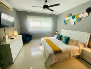 een slaapkamer met een bed en een plafondventilator bij Caribe Grand Dream in Playa del Carmen