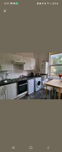 a kitchen with white appliances and a wooden table at Quiet Room Near Arsenal Stadium Islington Zone 2 Cental in London