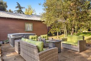 un patio con sillas de mimbre, mesa y parrilla en Buckthorn Beauty, en Descanso