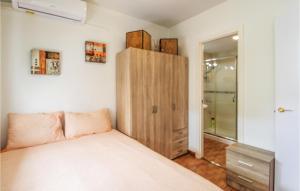 1 dormitorio con 1 cama y armario de madera en Gorgeous Apartment In Torremolinos With Kitchen, en Torremolinos