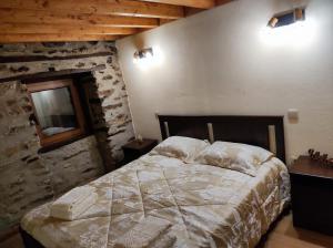 a bedroom with a bed and a stone wall at Recanto da Encosta - T2 in Bragança