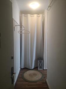einen Flur mit einem weißen Duschvorhang und einem Teppich in der Unterkunft Antik Apartman in Veszprém