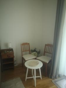 ein Wohnzimmer mit 2 Stühlen und einem Tisch in der Unterkunft Antik Apartman in Veszprém