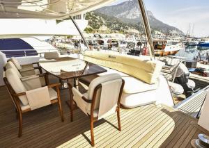 una cubierta de madera de un barco con mesa y sillas en Luxury Life, en Milas
