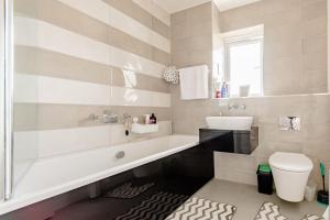 a bathroom with a tub and a sink and a toilet at Private Double bedroom in Thringstone