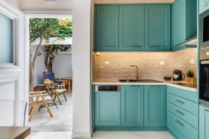a kitchen with blue cabinets and a dining room at Traditional House in Skopelos Town