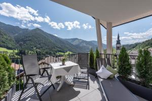 a balcony with a table and chairs and mountains at Living Puez in Funes
