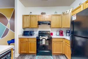 a kitchen with wooden cabinets and a black refrigerator at The Garrison Getaway in Fruitland