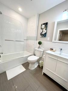 a white bathroom with a toilet and a tub and a sink at 305 Cozy and lovely 1BDR apartment in Center City in Philadelphia