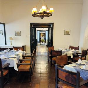 uma sala de jantar com mesas e cadeiras e um lustre em Hotel Hacienda Suescún em Tibasosa