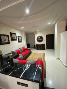 a living room with a red couch and a table at Super et magnifique Appartement. in Safi