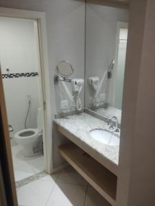 uma casa de banho com um lavatório, um WC e um espelho. em Quality Barra Jacarepaguá no Rio de Janeiro