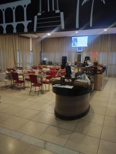 une salle à manger avec des tables, des chaises et un écran dans l'établissement Quality Barra Jacarepaguá, à Rio de Janeiro