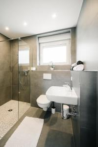 a bathroom with a toilet and a sink and a shower at Ferienwohnung Lindbruchblick in Niederkrüchten