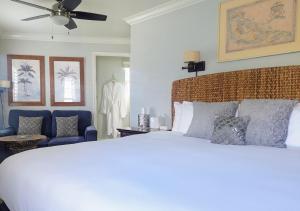 a bedroom with a white bed and a blue chair at Capitola Hotel in Capitola