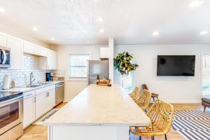 a kitchen with a large white counter top and chairs at The Jewel of Elkhart, Upper Unit in Elkhart