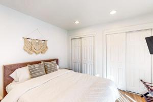 a white bedroom with a bed and a chandelier at The Jewel of Elkhart, Upper Unit in Elkhart