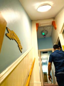 a man walking down a hospital hallway with a arrow on the wall at BunkHouse in Cardiff