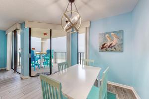 a dining room with a white table and chairs at Phoenix V 614 in Orange Beach