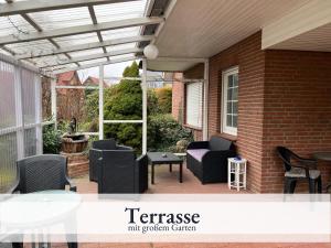 a pergola on a patio with chairs and a table at Blumenvilla 6 mit Küche, Balkon, Sauna und Garten in Schneverdingen