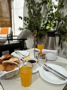 einen Frühstückstisch mit Brot, Kaffee und Orangensaft in der Unterkunft Hotel Piru Wasi in Arequipa