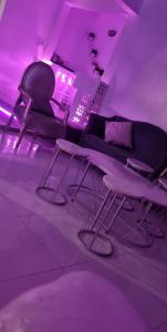 a room with a couch and a table and purple lights at شاليهات ليله الدرب in Qarār