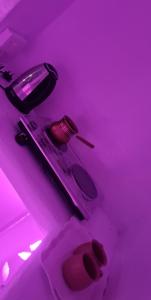 a room with purple lights and a toilet in a room at شاليهات ليله الدرب in Qarār