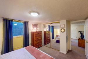 a bedroom with a bed and a dresser and a mirror at Elati Guesthouse in Denver